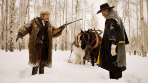 9. Os Oito Odiados (The Hateful Eight, 2015) Um caçador de recompensas (Kurt Russel), acompanhado por sua prisioneira (Jennifer Jason Leigh), se abriga em uma cabana cheia de personagens suspeitos durante uma nevasca.